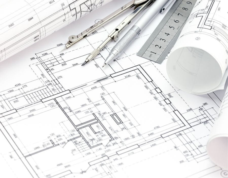 Detailed architectural house floor plan with drafting tools, technical drawings, and construction blueprints used for residential building design.