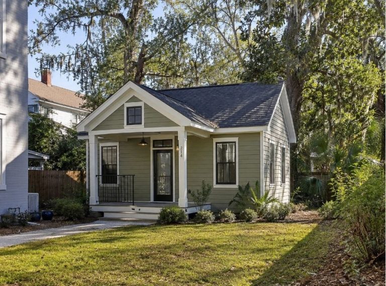 Modern backyard ADU home in Savannah, GA featuring a small cottage-style accessory dwelling unit with Southern architecture, landscaped yard, oak trees with Spanish moss, and a private residential backyard setting.